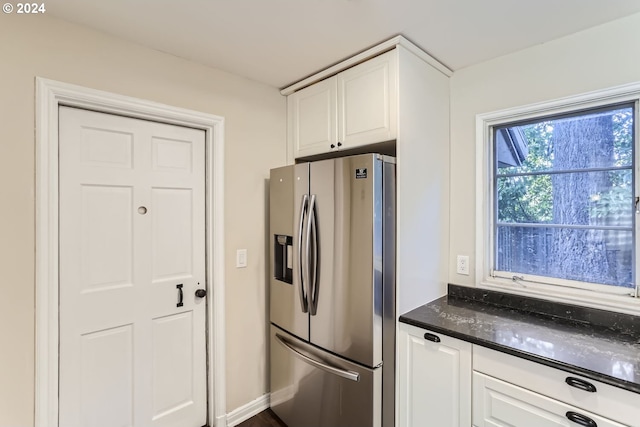 kitchen featuring white cabinetry and stainless steel fridge