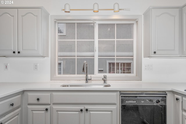 kitchen featuring dishwasher, sink, and white cabinetry