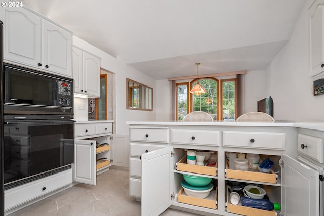 kitchen featuring black appliances, white cabinetry, and hanging light fixtures