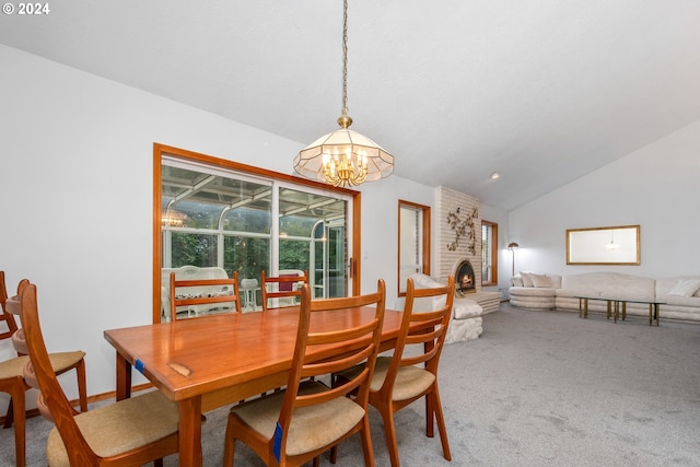 dining space with a fireplace, lofted ceiling, a chandelier, and carpet floors