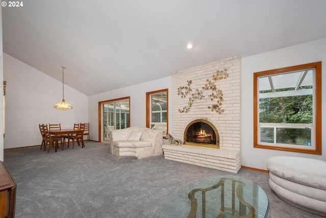 living room featuring lofted ceiling, a brick fireplace, and carpet flooring