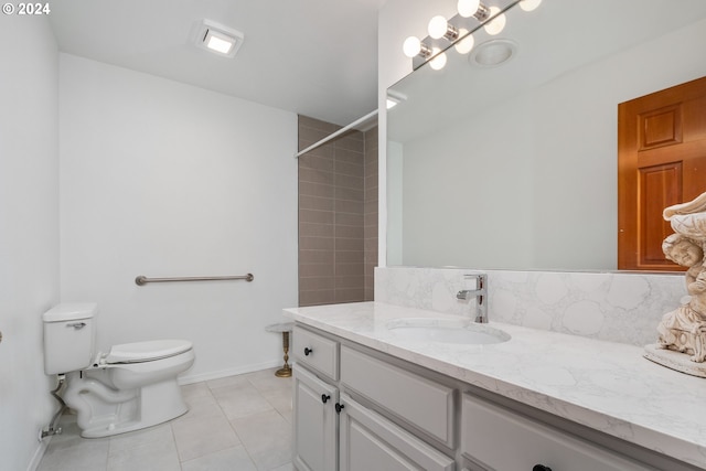 bathroom with tile patterned floors, tiled shower, toilet, and vanity