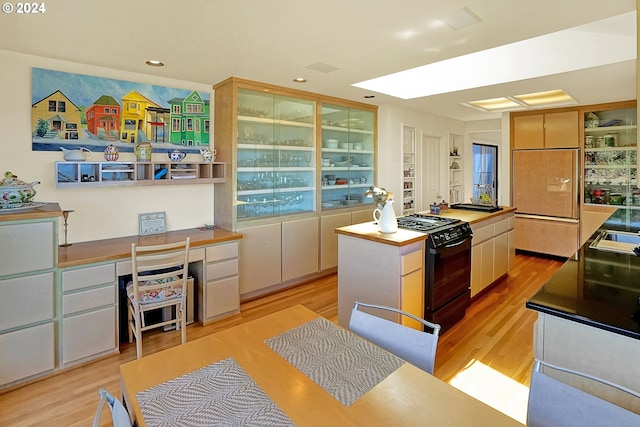 kitchen featuring recessed lighting, light wood-type flooring, black range with gas stovetop, and a center island