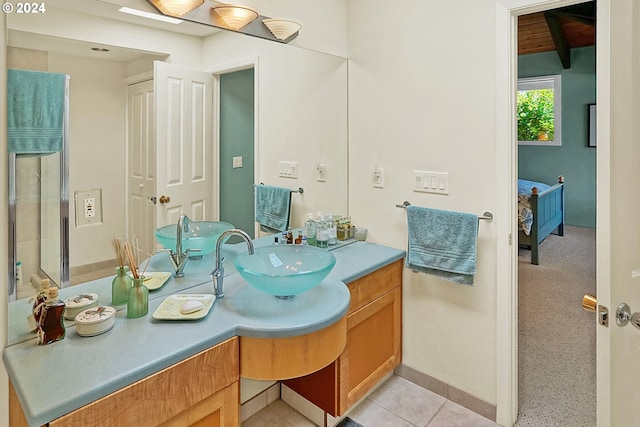 ensuite bathroom with vanity, ensuite bath, and tile patterned flooring