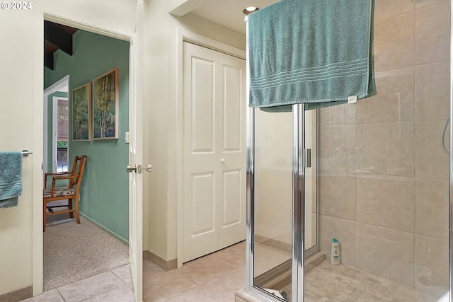 bathroom with tile patterned floors, baseboards, and a shower stall