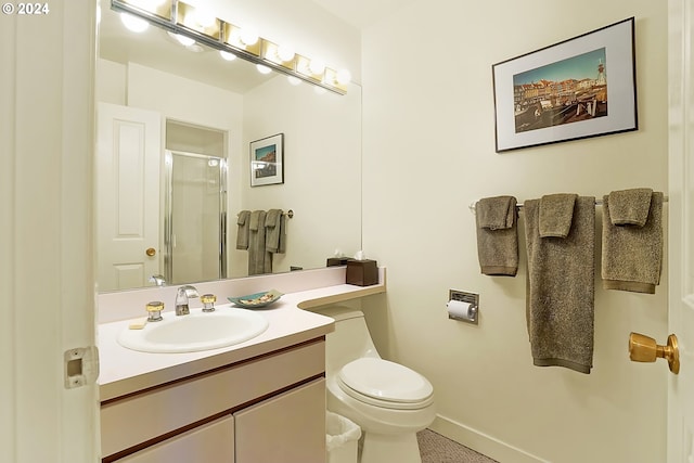 bathroom featuring baseboards, toilet, a stall shower, and vanity