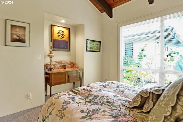 carpeted bedroom featuring multiple windows, baseboards, and vaulted ceiling with beams