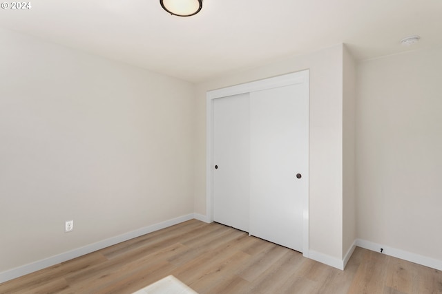 unfurnished bedroom featuring a closet and light hardwood / wood-style floors