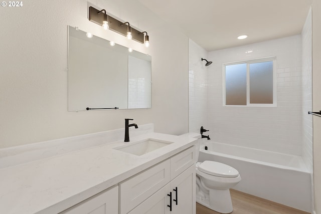 full bathroom featuring hardwood / wood-style flooring, vanity, toilet, and tiled shower / bath