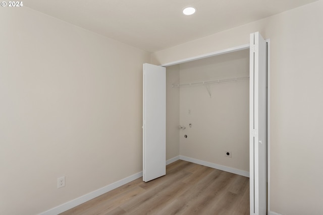 clothes washing area featuring light hardwood / wood-style flooring, hookup for an electric dryer, and hookup for a washing machine