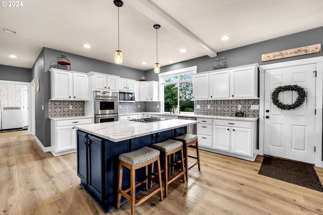 kitchen with appliances with stainless steel finishes, a center island, and white cabinets