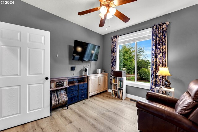 living room with light wood-type flooring and ceiling fan