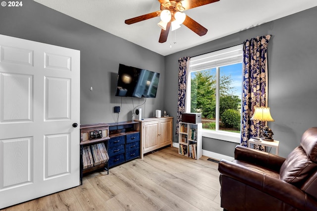 living room with ceiling fan and light wood-type flooring