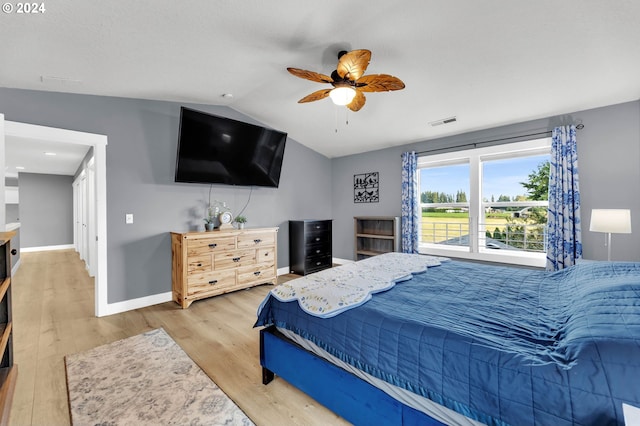 bedroom with ceiling fan, lofted ceiling, and wood-type flooring