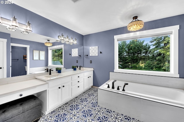 bathroom with tile patterned flooring, a relaxing tiled tub, and vanity