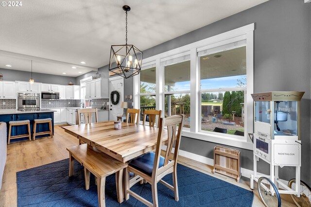 dining room with light hardwood / wood-style floors and a chandelier