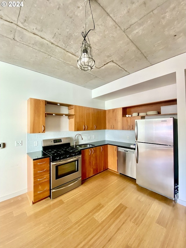 kitchen featuring appliances with stainless steel finishes, sink, and light hardwood / wood-style floors