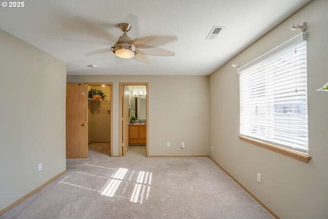 unfurnished bedroom with a spacious closet, light colored carpet, multiple windows, and visible vents