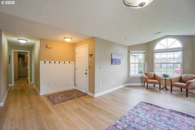 foyer with lofted ceiling, wood finished floors, and baseboards