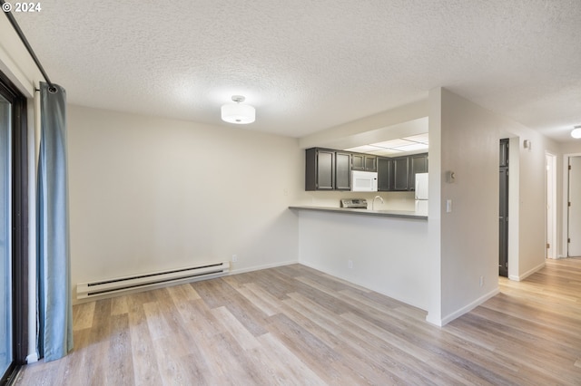 kitchen with white appliances, a baseboard heating unit, a textured ceiling, kitchen peninsula, and light wood-type flooring