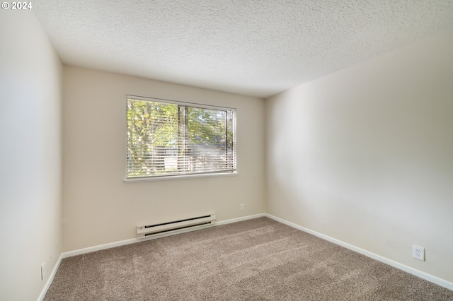 spare room with a baseboard radiator, carpet, and a textured ceiling