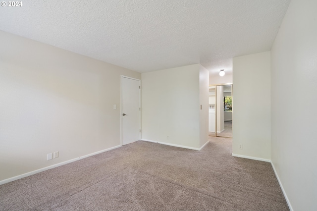 empty room featuring a textured ceiling and carpet flooring