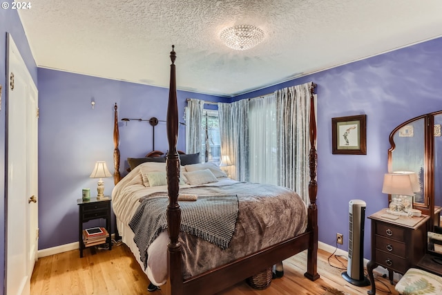 bedroom with light hardwood / wood-style flooring and a textured ceiling