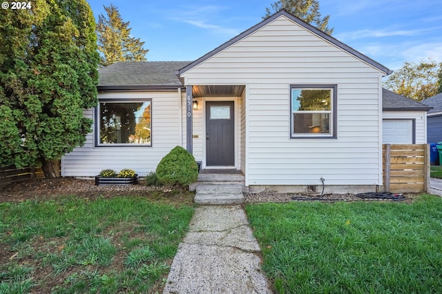 bungalow-style house featuring roof with shingles and a front lawn