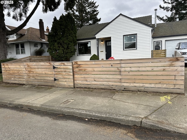 view of front of house with a gate, a shingled roof, and a fenced front yard