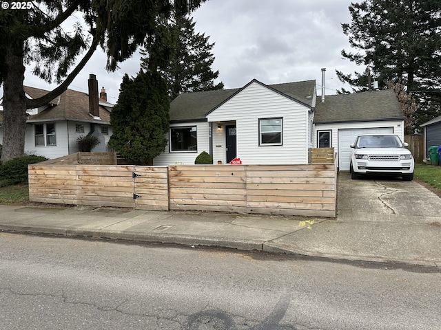 8510 SE Washington St, Portland, OR 97216 - bungalow with a fenced front yard, a shingled roof, a garage, and driveway