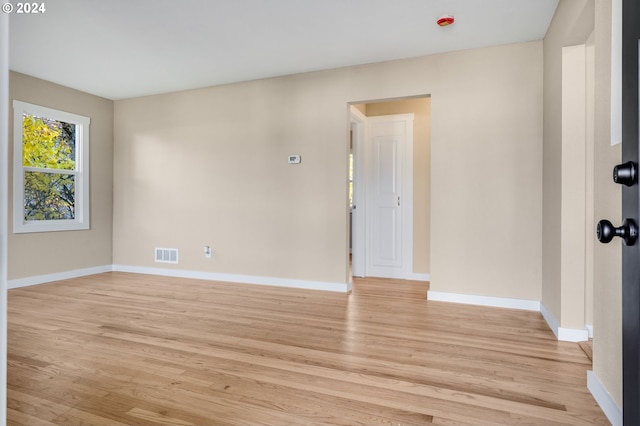 empty room featuring baseboards, visible vents, and light wood-style flooring