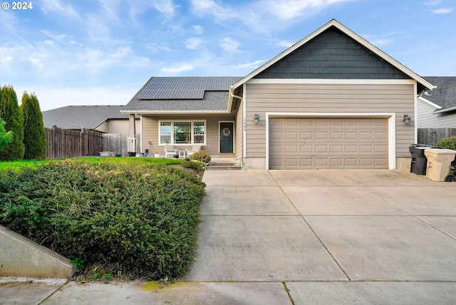 view of front of home featuring covered porch, solar panels, and a garage