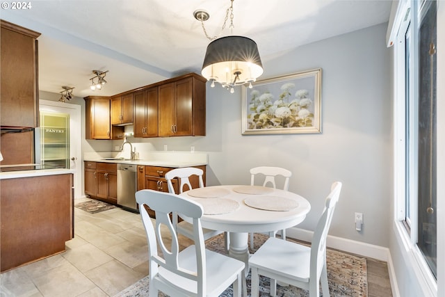 tiled dining space with a chandelier and sink