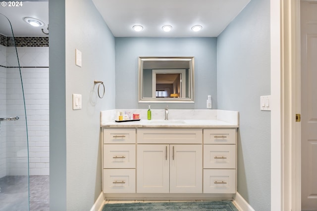 bathroom with vanity and a tile shower