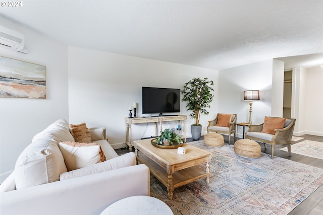 living room with wood-type flooring and an AC wall unit