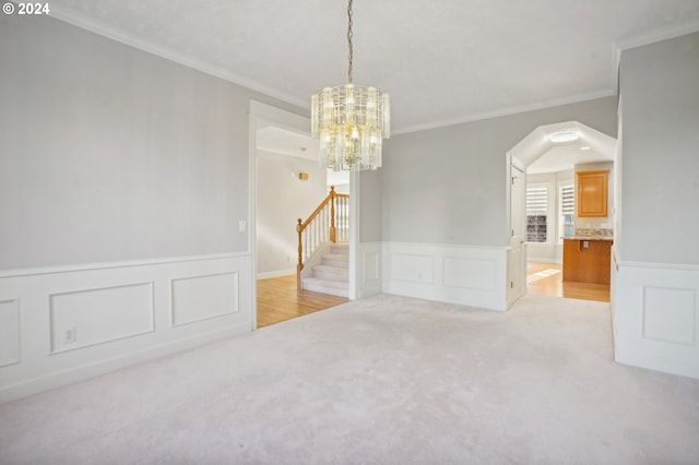 spare room with light carpet, a notable chandelier, and crown molding