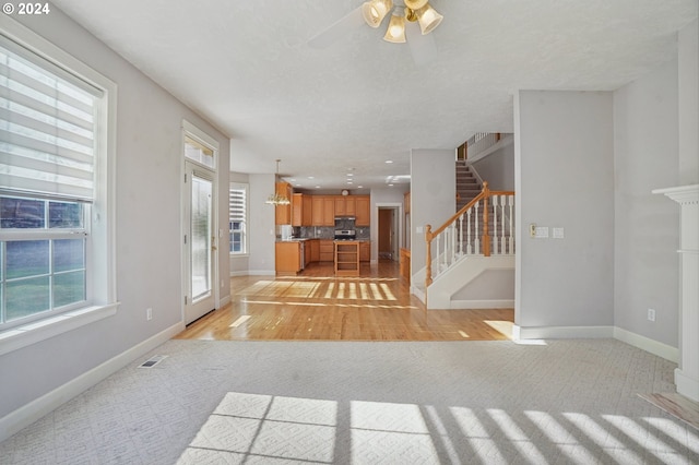 interior space with light hardwood / wood-style floors, a textured ceiling, and ceiling fan