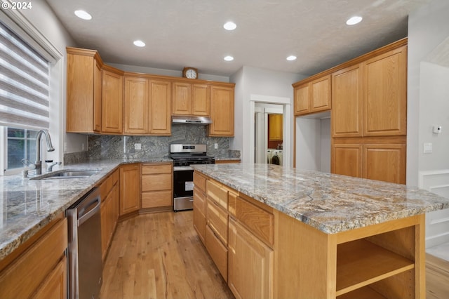 kitchen featuring light wood-type flooring, light stone counters, sink, and stainless steel appliances