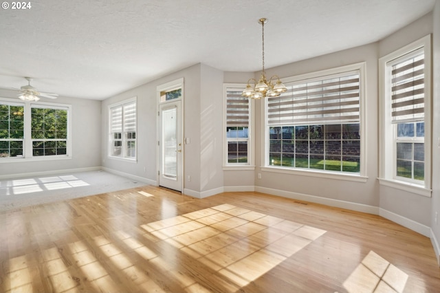 interior space featuring a textured ceiling, ceiling fan with notable chandelier, and light hardwood / wood-style floors