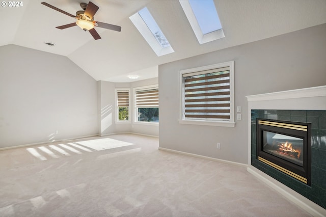 unfurnished living room featuring lofted ceiling, a tile fireplace, and light carpet