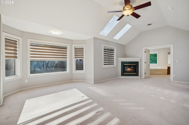 unfurnished living room featuring lofted ceiling, ceiling fan, and light carpet