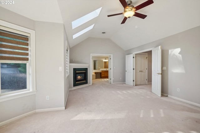 unfurnished living room with ceiling fan, vaulted ceiling, and light carpet