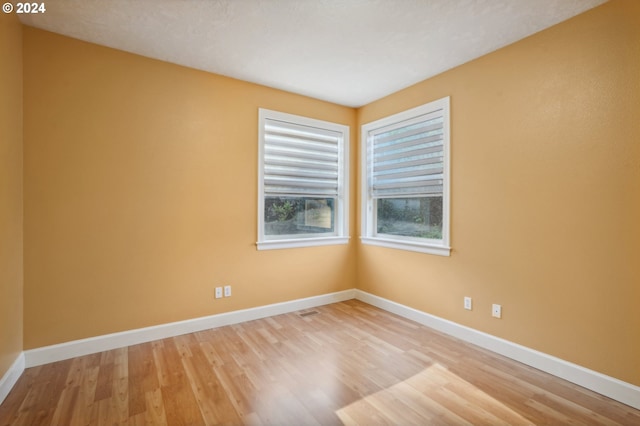 spare room with light hardwood / wood-style flooring and a textured ceiling