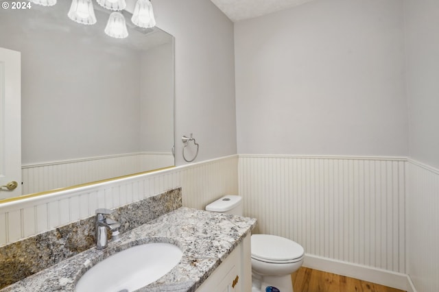 bathroom featuring hardwood / wood-style flooring, vanity, and toilet