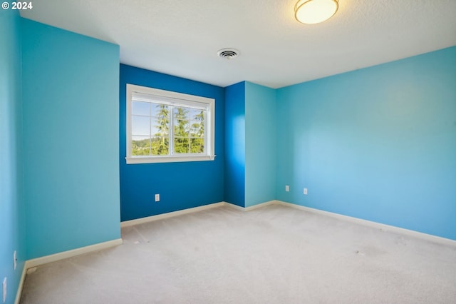 carpeted empty room featuring a textured ceiling