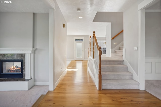 interior space featuring hardwood / wood-style flooring, a multi sided fireplace, and a textured ceiling