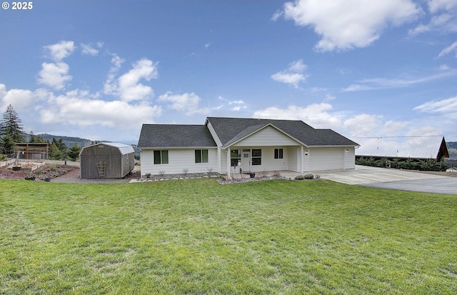 view of front facade with an outbuilding, an attached garage, a storage shed, driveway, and a front yard