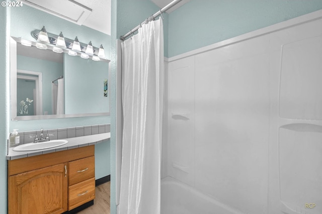 bathroom featuring tasteful backsplash, hardwood / wood-style floors, vanity, and shower / tub combo