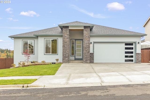 prairie-style house featuring a garage and a front yard