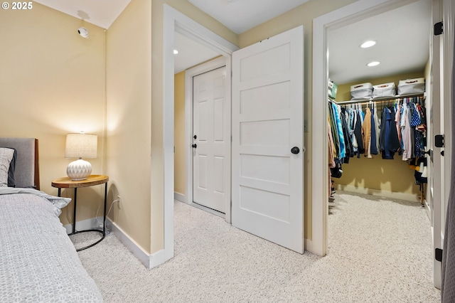 bedroom with a spacious closet, baseboards, a closet, and recessed lighting